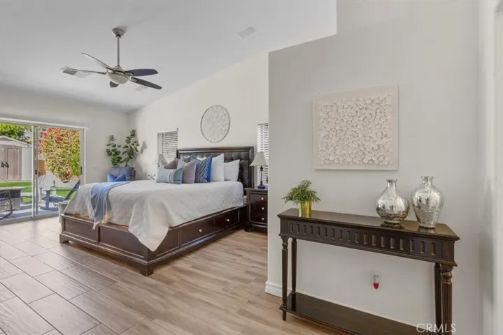 Primary bedroom with vaulted ceiling, sliding glass door with access to the backyard and ceiling fan.