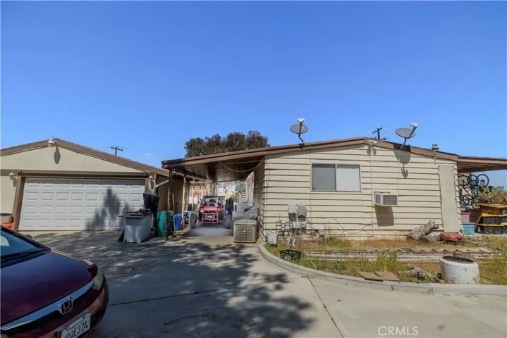 Triple-wide backside with 2-car garage and attached carport.