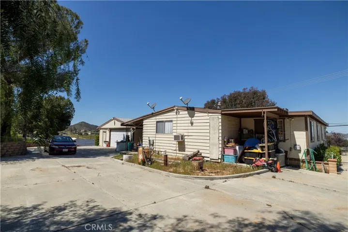 Backside of triple wide, showing 2-car garage and storage unit on left.