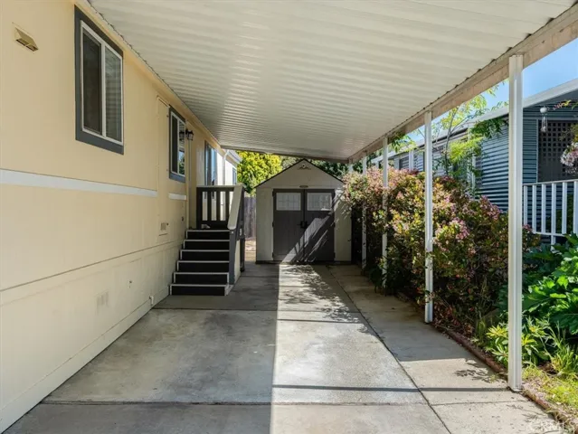 2-car Tandem carport offers a sheltered entry into the laundry room. Just in case you need more space... there's a large storage shed at the back of the carport.