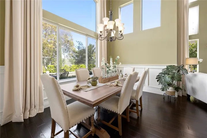 Wall of windows give you exceptional views. Wainscoting and two story tailored draperies with contrasting Expresso flooring are a model home picture