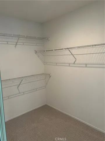 Primary suite walk in closet with mirror wardrobes