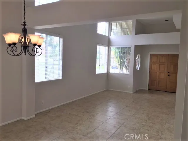 Dining room and living room with title floors, high ceilings.