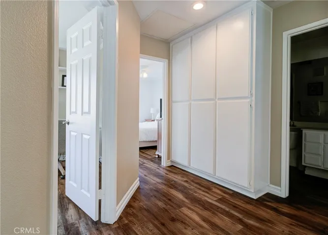 Top of stairs, looking into 2 secondary bedrooms & secondary bath. Upstairs features rich wood-laminate flooring