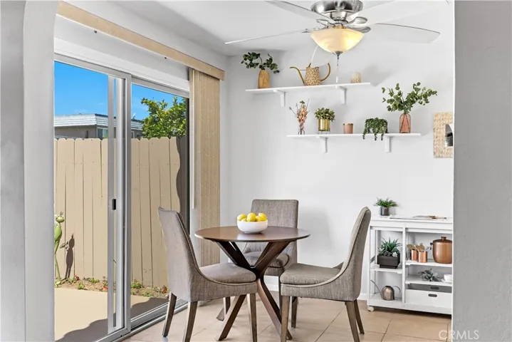Dining Room off kitchen and patio with ceiling fan and shelving.