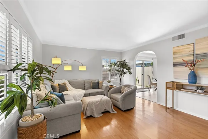 Spacious Living Room with shutters and arched entry to kitchen and Dining Room.