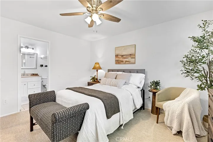 Large primary bedroom with ceiling fan, dual pain windows, mirrored wardrobes, new carpet, fresh paint and more.