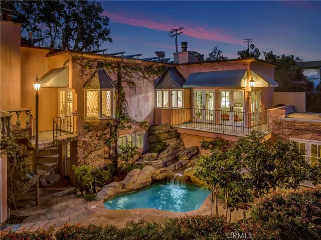 A beautifully landscaped backyard features an oversized spa with waterfall.