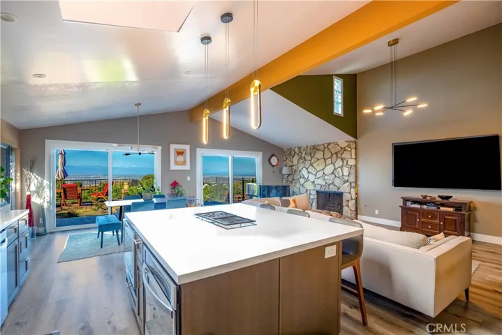Updated kitchen with open floorplan and nice Quartz countertops, custom lighting, and vaulted ceilings