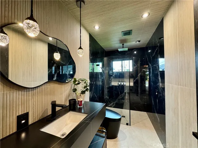 Elegant bathroom with designer details, ribbon tile, modern vanity, pendant lights