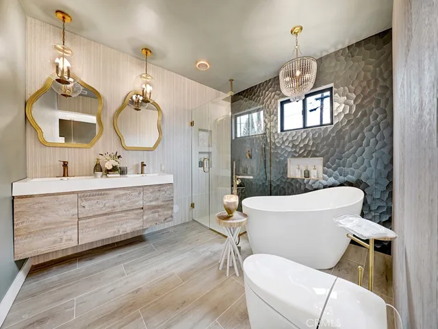 Master bathroom with sophisticated finishes, stunning shower walls, floating vanity with dual sinks, stand alone tub , stylish mirrors, lighting fixtures and chandelier