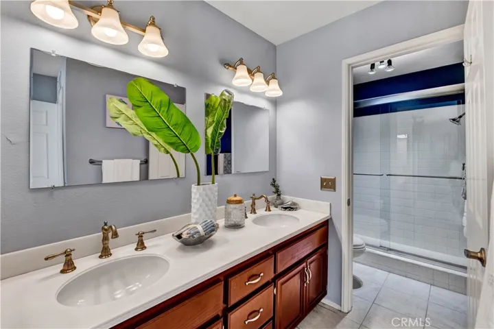 Ensuite Bathroom with Dual Sinks, Tile Flooring, and a Tiled Walk-In Shower!