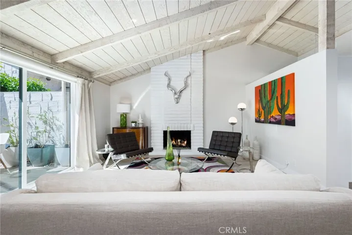 Beamed cathedral ceiling and large sliding glass doors on either side of the open living space.