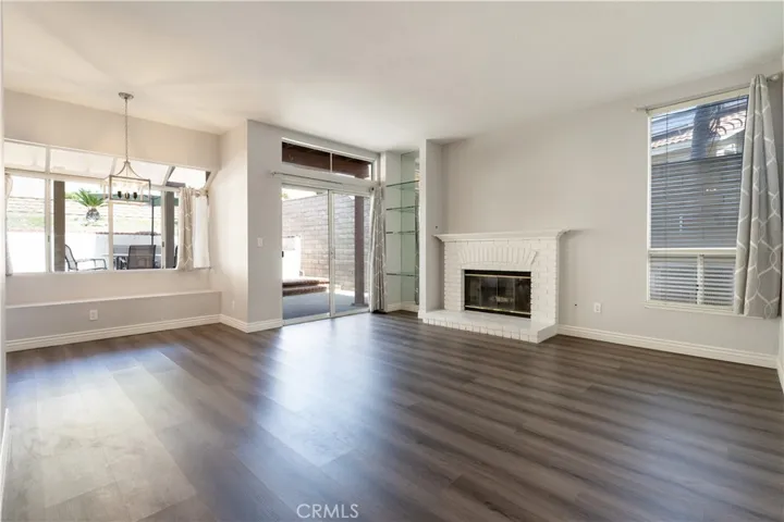Family Room w/ Hearth Fireplace & Sliding Glass Door leading to backyard.