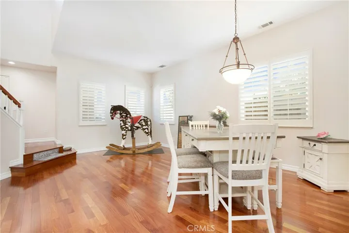 Formal living and dining graced with hardwood flooring and plantation shutters.