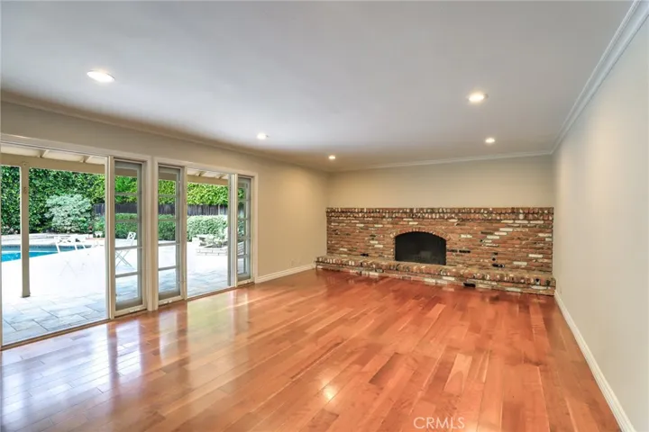 The large family room with a grand fireplace, crown molding, recessed lighting and access through French doors to the amazing entertainers backyard with sparkling pool!