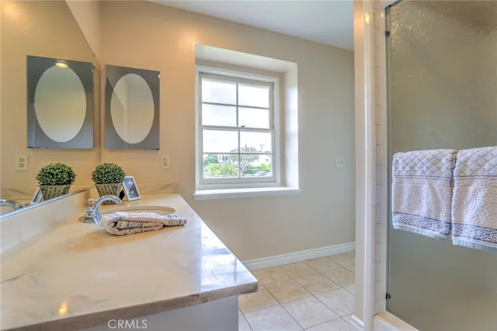 The primary suit bathroom with large vanity and shower. and window for added natural light.