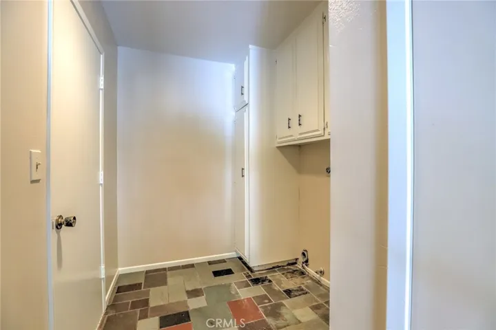 Large indoor laundry room with slate floors and storage!