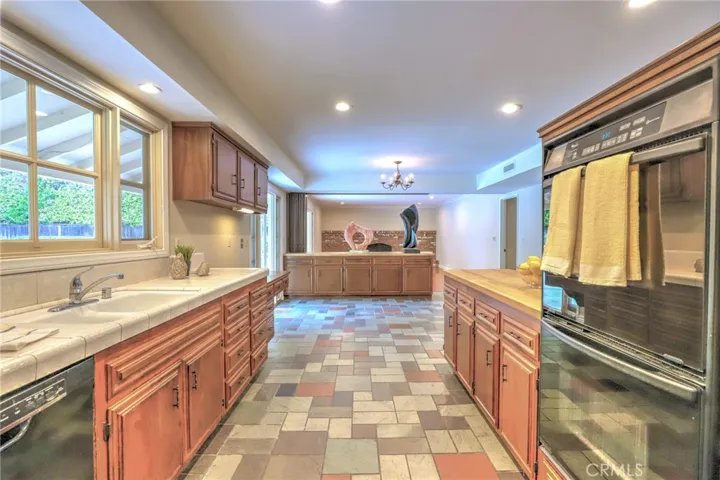 View of the large kitchen with beautiful state floors, large widow looking out to the backyard, recessed lighting and lots of storage.