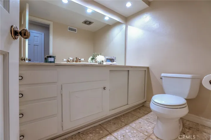 Downstairs bathroom with large vanity and storage.