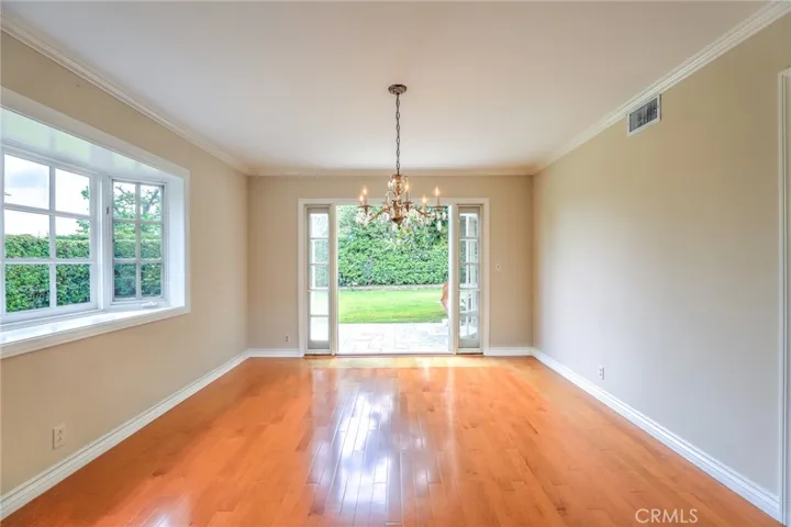 The dining room with large bay window, crown molding and French doors leading to a charming private patio.