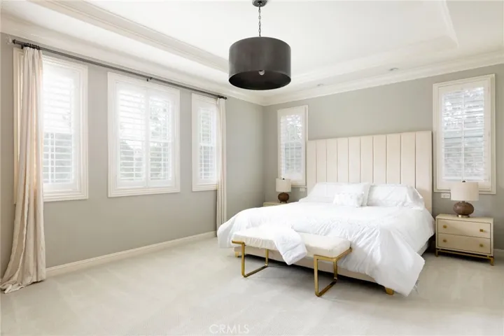 Tranquil primary bedroom retreat with views of lush trees.