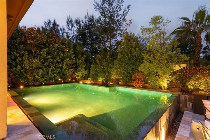Inviting backyard oasis with infinity pool and water features.