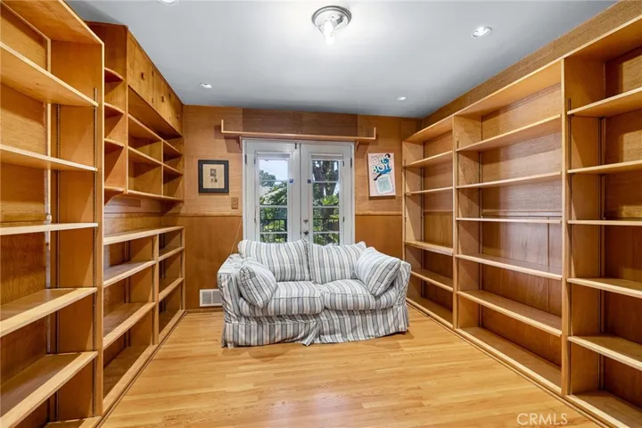 Bedroom three, previously used to store records, a closet would need to be added to convert back to a bedroom. There are also French doors leading to the backyard.