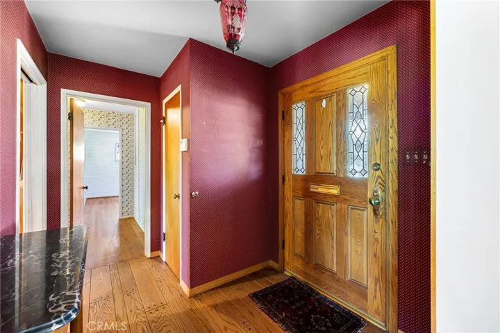 Front entryway with peg and groove hardwood floors that run through the living room.