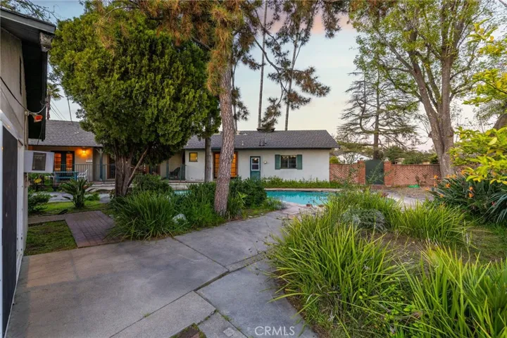 Backyard toward the pool and second outbuilding/dwelling previously used as a guest house.