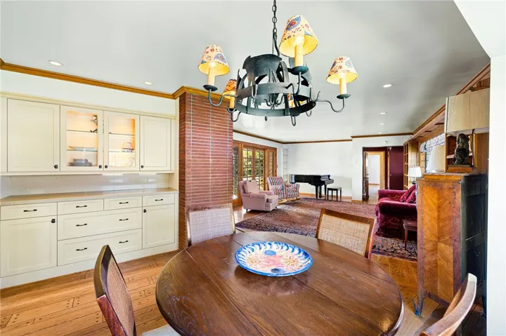 Open dining room with a custom built-in with glass uppers and stone countertops.