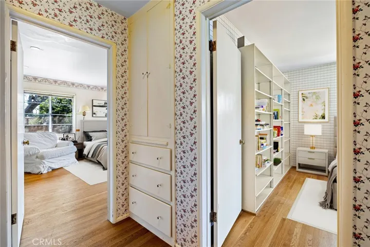 Hallway at bedroom entry with built-in linen storage.