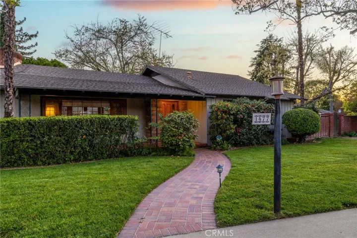 Brick walkway leading to the covered front porch tiled with Spanish pavers.