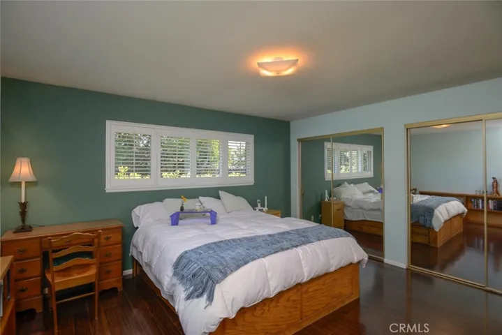 Primary suite boasts upgraded laminate flooring and dual mirrored door wardrobes
