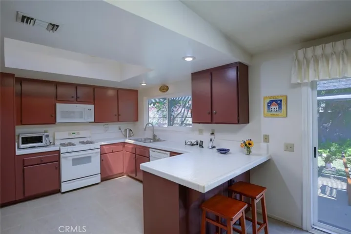 Bright, cheerful kitchen with skylight, recessed lighting and convenient breakfast bar