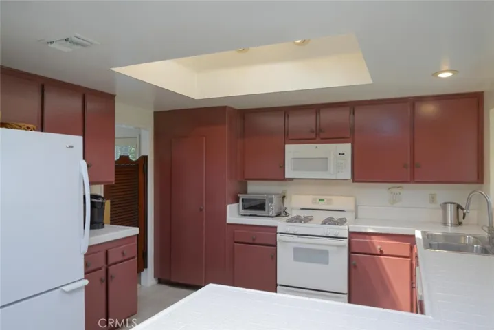 View of kitchen with spacious pantry & swinging door to dining area