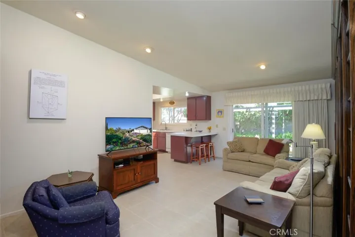 Family room with recessed lighting and partial view of adjacent kitchen