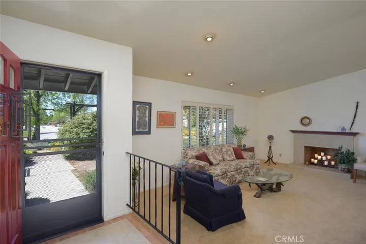 View from raised entry to formal living room with cozy fireplace