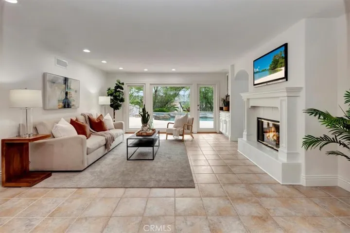 Family room with cozy fireplace, dry bar, & French doors leading to the backyard.
