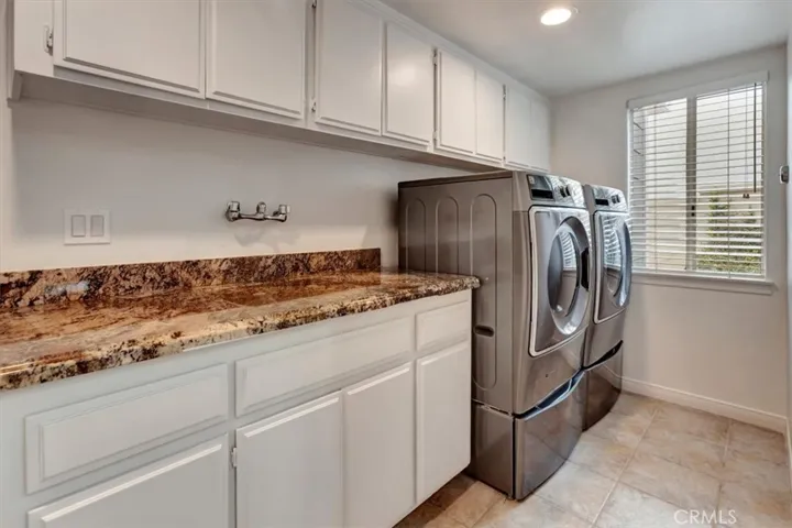 A convenient laundry room w/utility sink, ample cabinets, & direct access to the 3-car garage.