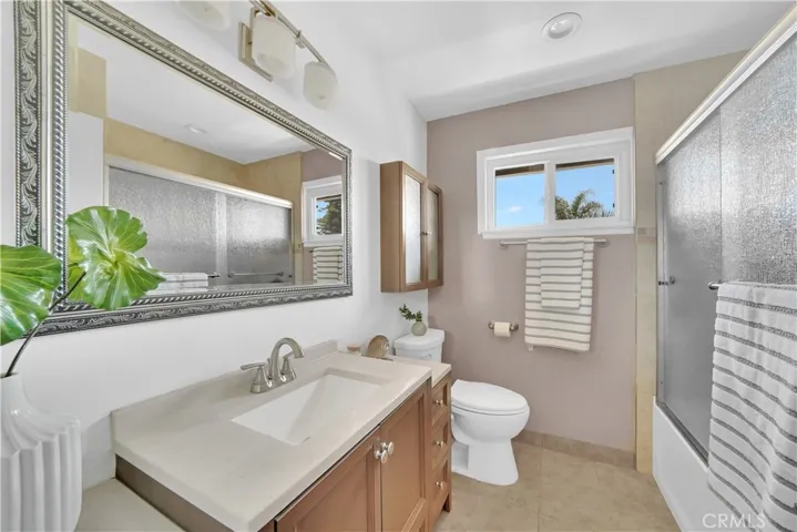 A recently remodeled bathroom with a new vanity, towel storage and tub/shower combo with glass doors adds a touch of sophistication.