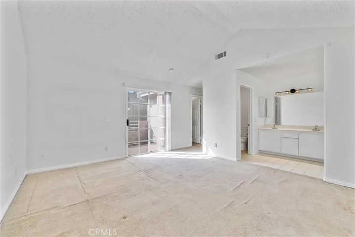 large primary bedroom has a slide door to the balcony