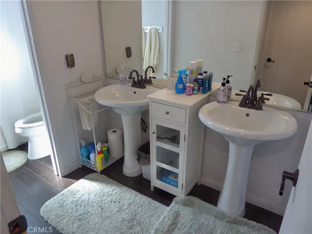 Second Floor Bathroom with double Pedestal Sinks, Toilet, Tub & Shower.