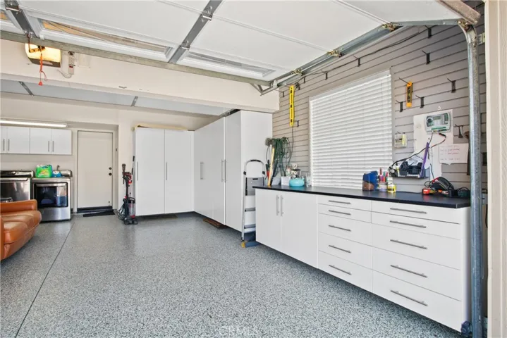 Garage has overhead rack storage, secured cabinets and a very handy workbench. I love the pegged wall to hang items. APOXY floor make it easy to clean for messes. Side by side washer/dryer space (machines not included)