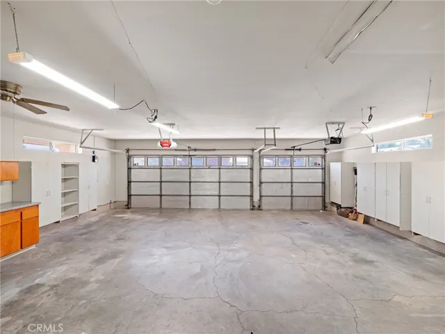 Very deep garage hosts many cabinets, sink & counters