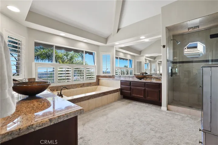 Enjoy the Spacious Primary Bathroom with a Large Soaking tub, two areas for dressing, large upgraded walk-in shower and a double closet with Custom Closet Organizers