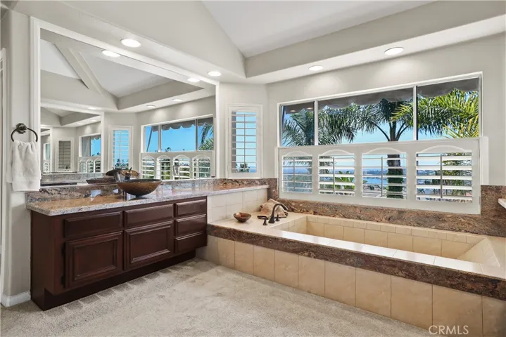 Mirrored Bathroom Walls and Panoramic Lake Views from the Primary Bathroom create a Spacious Luxurious Ambiance for your early morning enjoyment