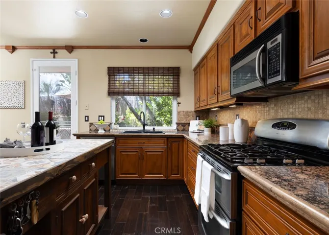 The kitchen features a gas range and oven and stainless steel appliances.