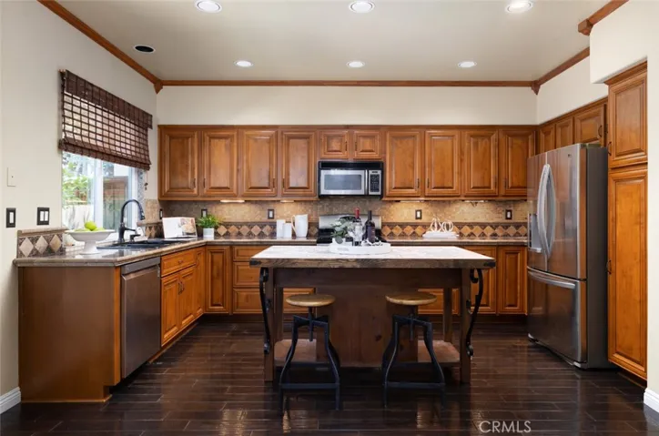The upgraded kitchen is a chef's dream, equipped with beautiful cabinets with soft close, kitchen island and granite tile counters.