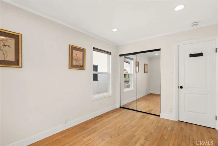 Guest room with mirrored closet doors.